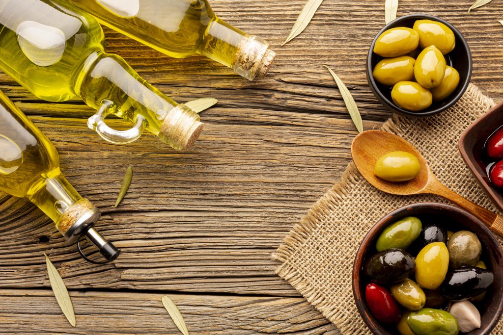 Premium extra virgin olive oil with fresh olives and herbs arrangement